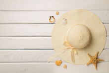 Beautiful Straw Hat And Seashells On Wooden Background, Top View