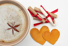 Cup of coffee with spices, romantic notes with wishes and two hearts made from dried orange peels