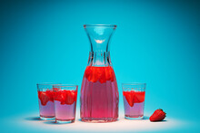 Carafe And Glasses With Strawberry Lemonade On A Turquoise Background