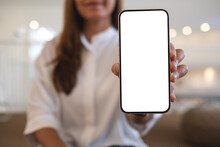 Mockup Image Of A Young Asian Woman Holding And Showing A Mobile Phone With Blank White Screen
