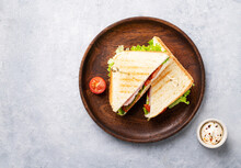 Club Sandwich On A Wooden Plate Of Ham Cheese, Cucumber, Tomato And Lettuce Leaves On A Blue Background With Mayonnaise. Top View And Copy Space