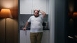 Portrait of frustrated overweight man stand in small kitchen