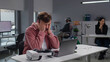 © TommyStockProject - Businessman take off vr goggles and massage tired eyes sitting at desk in modern office