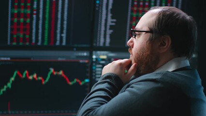 Close up of pensive fat trader look at multiple computer screens with data