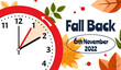 Banner of Daylight Saving Time Ends November 6, 2022. Alarm Clock Set To Clock Back One Hour on Background Autumn Foliage. WinterTime, Fall Back.
