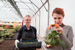 © Natalia Navodnaia - Couple of women - gardener and customer choose plants in professional greenhouse of garden mall.