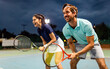 © NDABCREATIVITY - Beautiful young people are playing tennis as a team on tennis court outdoors. People sport concept