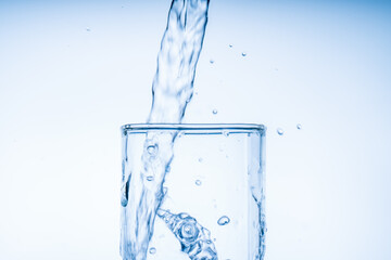 Canvas Print - Ice cube fell into the glass of water. Water splashed from the clear glass. Fresh concept