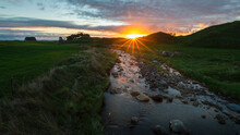 Stony River Lit Up By Sunbeams At Sunset, Taranaki, New Zealand.