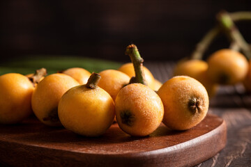 ripe loquat fruit on wooden table