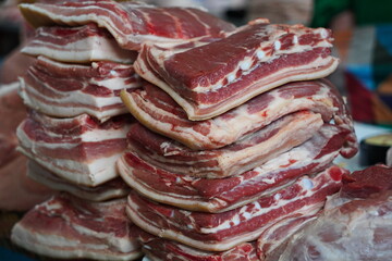 Almaty, Kazakhstan - 03.25.2022 : Pork slices are laid out in a row for sale in a hypermarket.