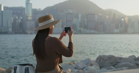 Poster - Travel woman use cellphone to take photo in Hong Kong city