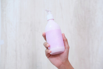 Wall Mural - Close-up of a woman's hand showing a lotion beauty product on a gray background