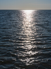 Canvas Print - Glittering of evening sunlight reflects on sea surface. Sparkling sunlight over sea surface on waves. Sparkling water background.