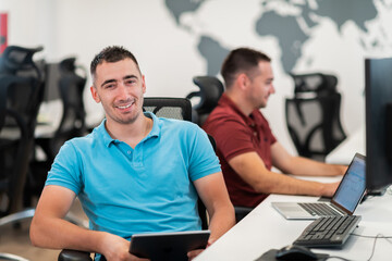 Group of Casual business man working on desktop computer in modern open plan startup office interior. Selective focus 