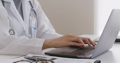 Asia smart people female GP hands chat on telehealth telemedicine teleconsult app to online patient on laptop sit work at clinic office desk, enter Rx exam record data, share lab blog or write e-mail.