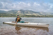 senior male wearing life jacket is paddling a decked expedition canoe on a mountain lake - Horsetooth Reservoir in northern Colorado in spring scenery