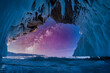 Landscape of milky way on sky with natural breaking ice inside blue ice cave on Lake Baikal, Siberia, Russia.