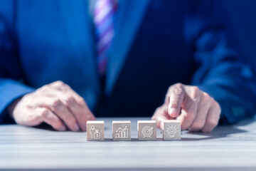 Wall Mural - Businessman arranging wood block stacking with business icons