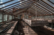 Old abandoned greenhouses. Dead plants. Interior of an abandoned building. Sunny day. Wooden greenhouses.
