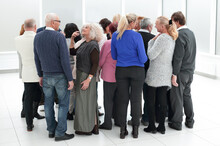 A Group Of Old People Standing With Their Backs Indoors