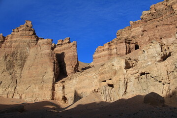 Wall Mural - Flat relief walls and rocks of the sandy-clay canyon Charyn against the sky with clouds, sunny