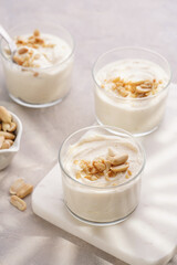 Wall Mural - Creamy dairy yoghurt dessert with mascarpone, cream cheese and peanut butter in glasses on marble tray