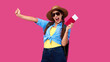 © khmelev - Excited female tourist holding passport and traveling tickets over pink isolate background. Woman student in summer casual clothes. Smiling caucasian woman in sunglasses.