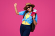 © khmelev - Amazed and smiling woman traveler in straw hat and sunglasses holding plane ticket and passport on pink isolated background