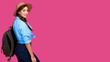 © khmelev - Positive woman traveler in casual clothes, straw hat and backpack on pink isolated background. Young smiling caucasian tourist