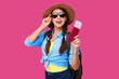 © khmelev - Woman tourist with traveling tickets and passport over pink isolated background. Female traveler in summer straw hat and sunglasses over pink isolated background. Tourism concept