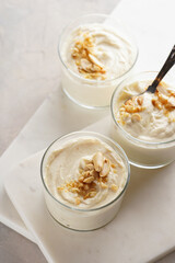 Wall Mural - Creamy dairy yoghurt dessert with mascarpone, cream cheese and peanut butter in glasses on marble tray with a tea spoon