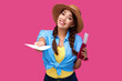 © khmelev - Young smiling woman tourist with passport giving flight ticket. Caucasian traveler in summer casual clothes in pink isolated background. Female student with document