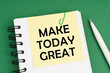 © Dzmitry - On a green surface, a pen, a notepad with stickers and the inscription - Make Today great