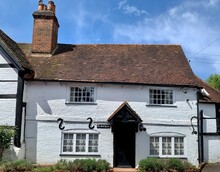 SONNING, ENGLAND. Fragment Of Facade Of Old Cottage In English Countryside. Medieval Half Timbered House With Stained Glass Windows, Black Door And Tile Roof In Berkshire. Selective Focus