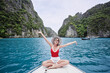 Traveling by Thailand. Pretty young woman enjoying view sailing on the yacht by Phi Leh lagoon.
