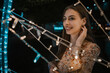 © Ahmed - Happy young caucasian woman amazed by LED fairy lights at city outdoor
