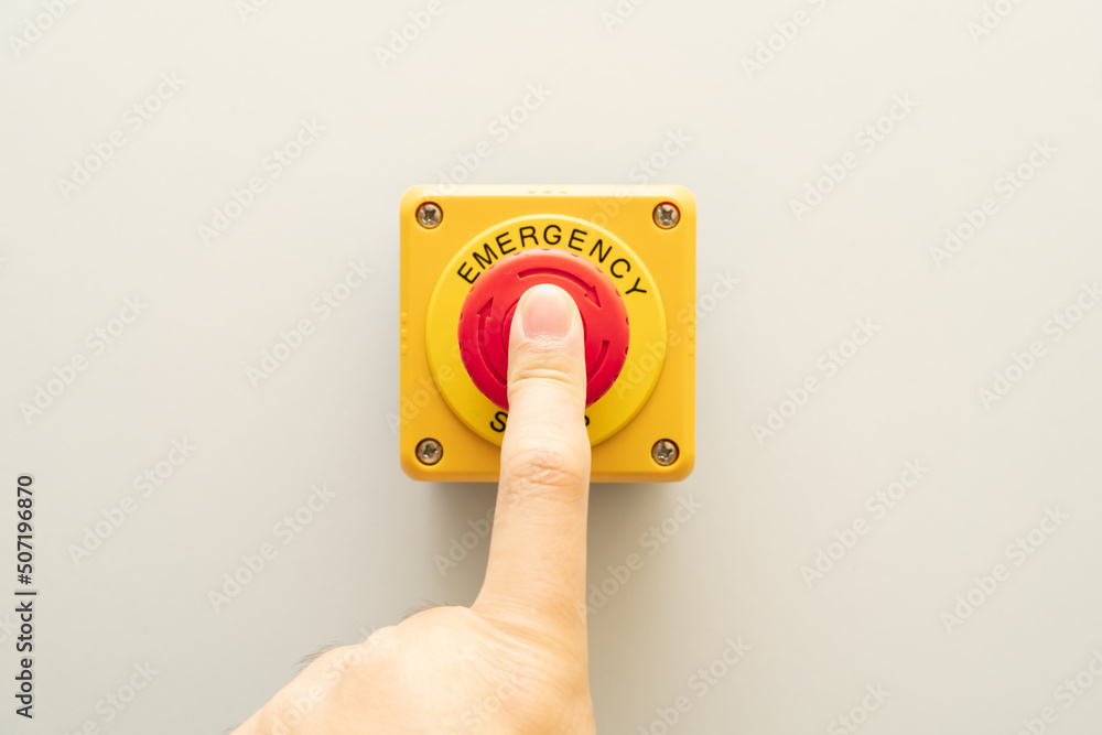 Stop Button and the Hand of Worker About to Press it. emergency stop button. Big Red emergency button or stop button for manual pressing