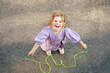 Little preschool girl jump and train with skipping rope. View from above on cute happy active child. Summer sports and activity for physical and mentally fitness of children.