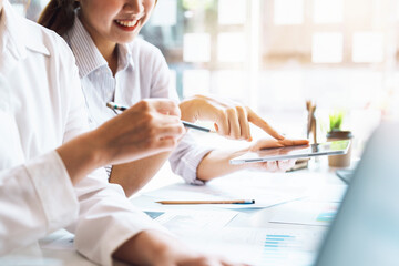 Wall Mural - Negotiation, Analysis, Discussion, Asian woman economist and marketer using tablet computer to plan investments and financial to prevent risks and losses for the company