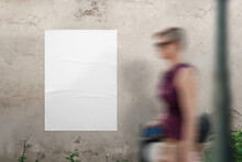 Blank Poster Mockup On The Wall For Design Presentation. A Young Woman Walks Past