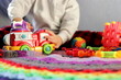 silhouette of a child against the background of a variety of colorful toys in the process of playing selective focus, children's toys