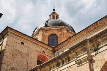 Urbino, Italy - 05 05 2020: Famous cathedral in the historic center of Urbino. Bottom view of the main church dome. Ancient Italian style. Architecture and summer tourism.