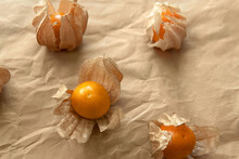 Fresh Picked Fresh Cape Gooseberry And Peruvian Groundcherry Fruit Or Rasbhari Packaging With Brown Crumpled Wrap Paper Background. High In Vitamin C Antioxidants Help With Eyesight