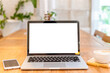 © Thinapob - Mockup of laptop computer with empty screen with coffee cup and smartphone on table of the coffee shop background,White screen
