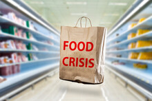 Food Crisis. Humanitarian Problem. Food Shortage Crisis. Food Crisis Inscription On Shopping Bag. I'll Run Over Price Increase Concept. Blurred Supermarket In Background. Hunger Crisis