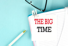 THE BIG TIME Text On A Sticky On Notebook With Pen And Glasses , Blue Background