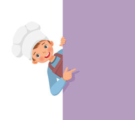 Wall Mural - cute little boy in chef hat and apron peeking from board pointing finger to empty banner for copy space