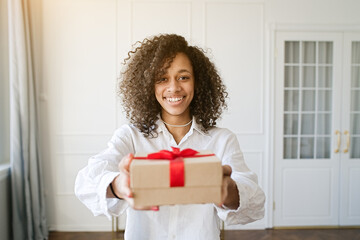 Excited african american young woman present gift box with ribbon. Family lifestyle, valentine's day, birthday holiday concept 