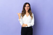 © luismolinero - Young caucasian woman isolated on purple background pointing to the side to present a product